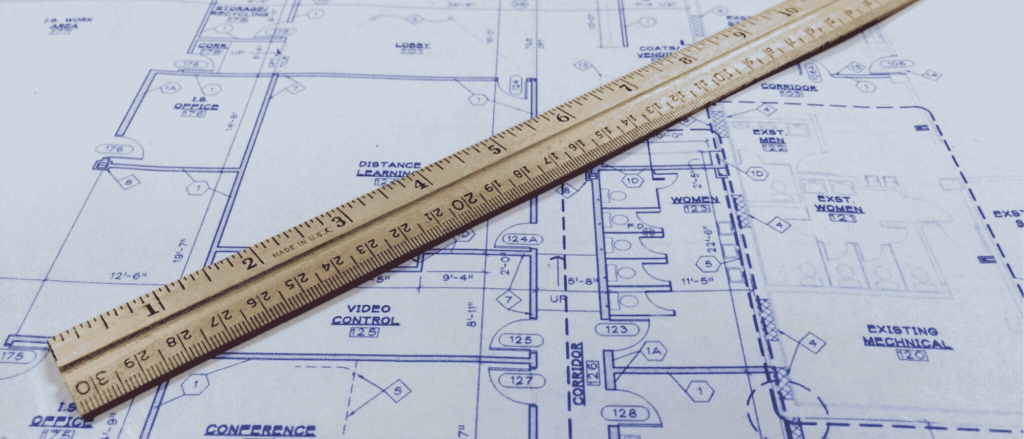 An architectural blueprint with a wooden ruler, representing a will and trust designed to work together