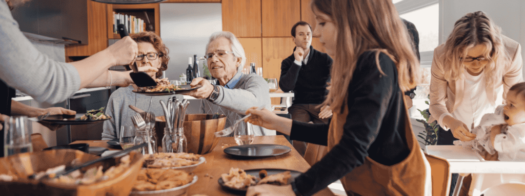 Three generations of a family sharing a meal around a kitchen table, a natural setting for a conversation about the family's plans