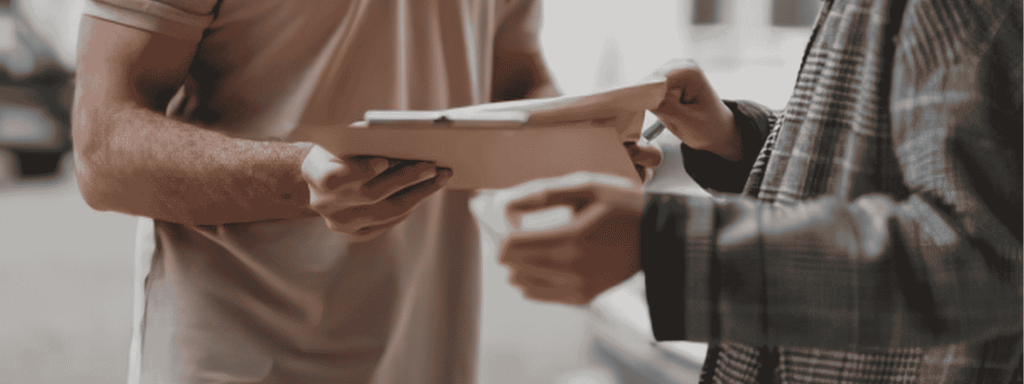 One business owner handing a tablet to a colleague, representing a planned business succession