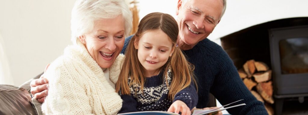 Grandmother reading a book with her young grandchild, a family that may use my529 for grandparents to save for education