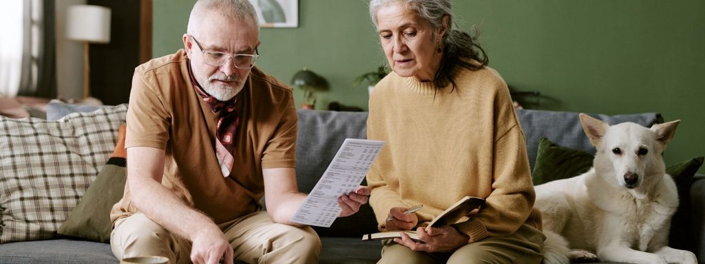 Retired couple reviewing financial documents at home while planning a Roth conversion before RMDs