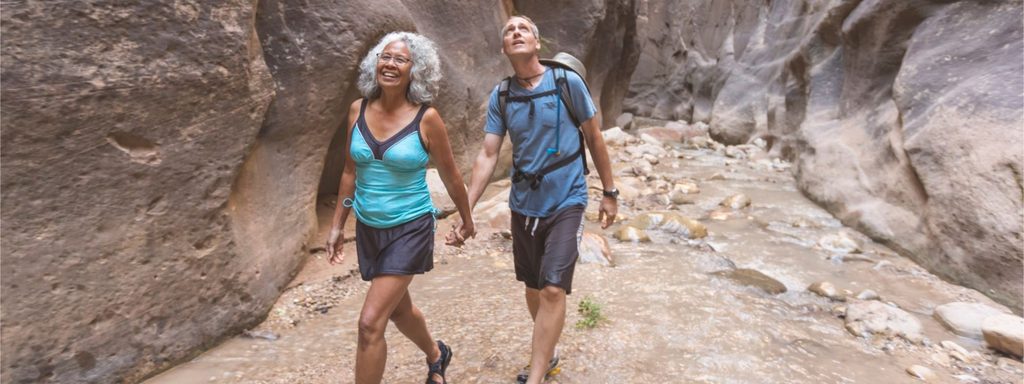 Retired couple walking a red rock trail in Utah, where state tax on retirement income affects their plan