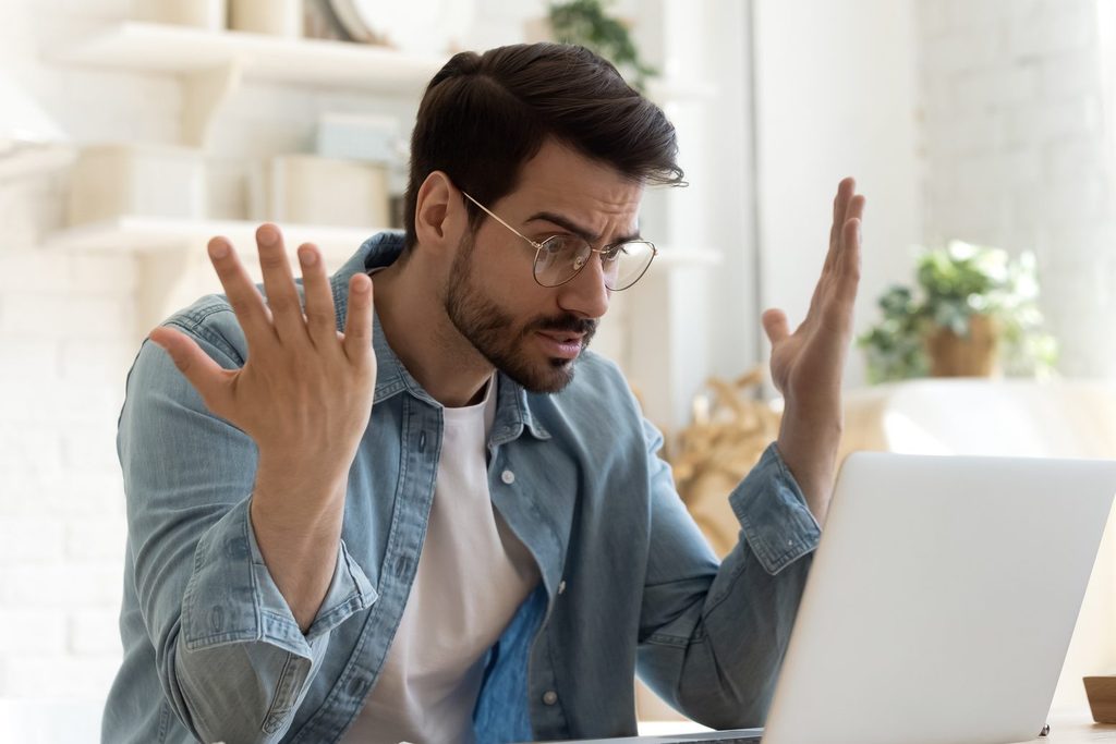 Frustrated man at a laptop, illustrating low consumer sentiment despite a strong economy in April 2026