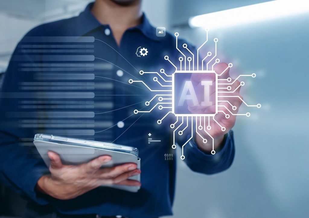 Professional holding a tablet beside a glowing AI chip graphic, illustrating broadening AI market leadership in February 2026