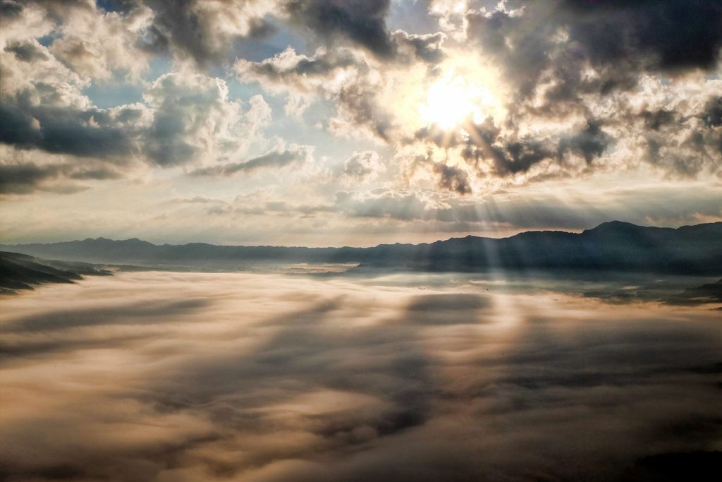 Sun breaking through clouds over a valley, as markets held steady through a noisy July 2026