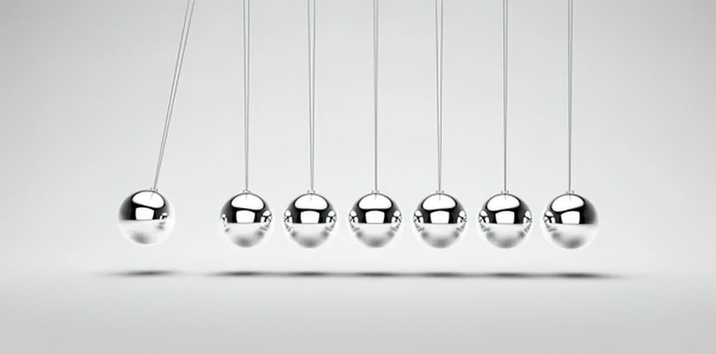 Newton's cradle in motion, illustrating balance between optimism and caution